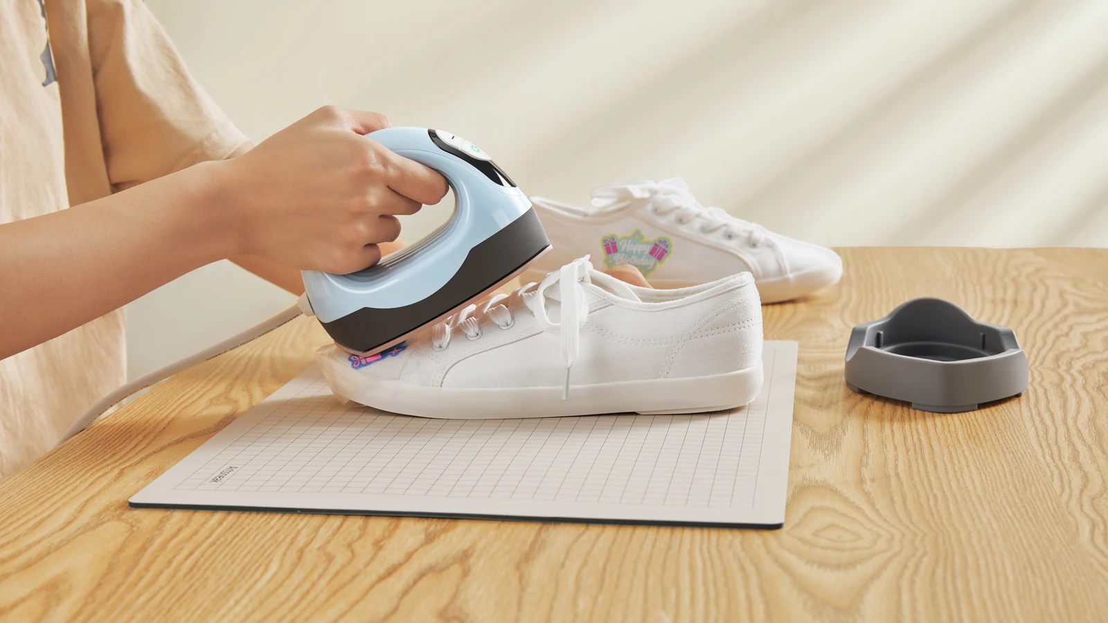 Blue LOKLiK ImPress Mini 3 applying a transfer to a white canvas shoe.