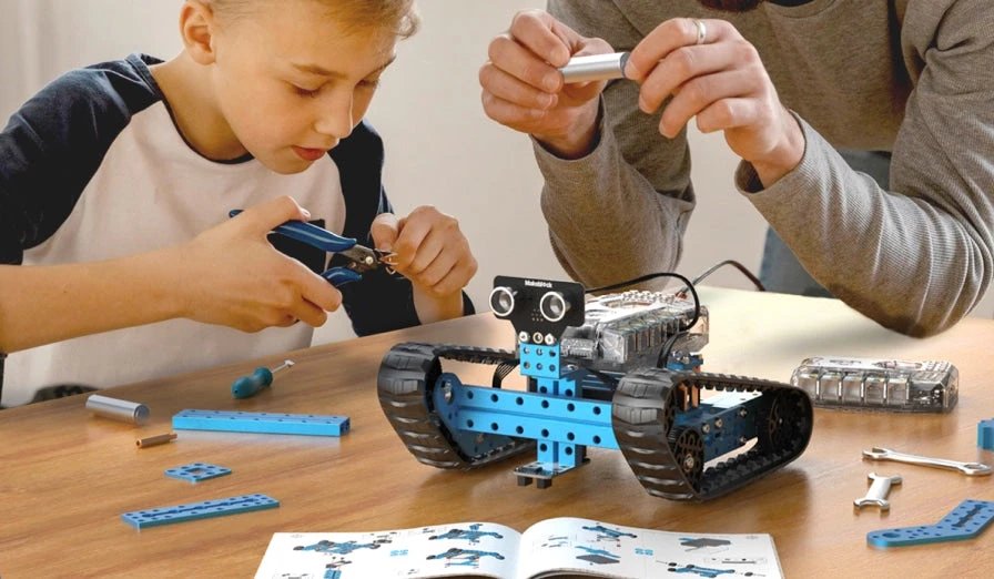 Child and adult assembling an mBot Ranger together.