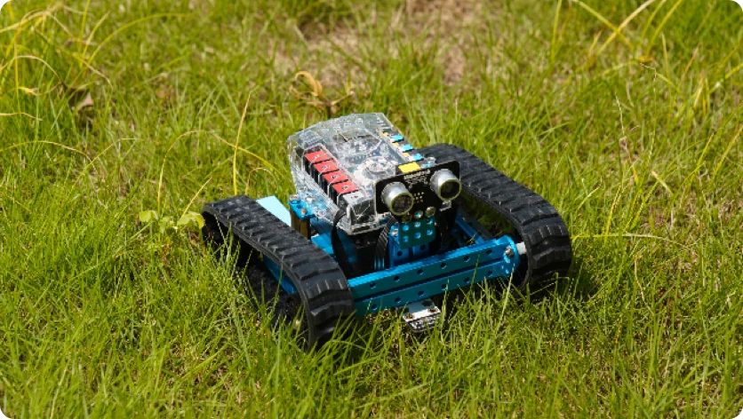 Tracked mBot Ranger on grass outdoors.
