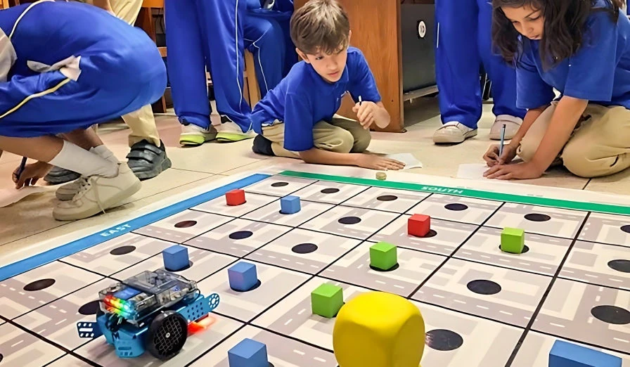 Students working with the standard wheeled mBot2 on a coding activity mat