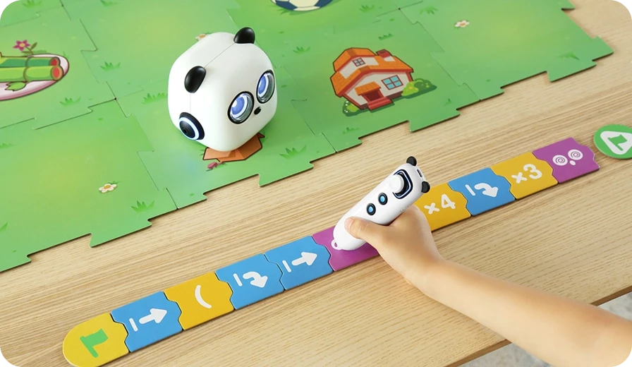 Hand using the mTiny tap pen with coding cards beside the robot and a puzzle map.