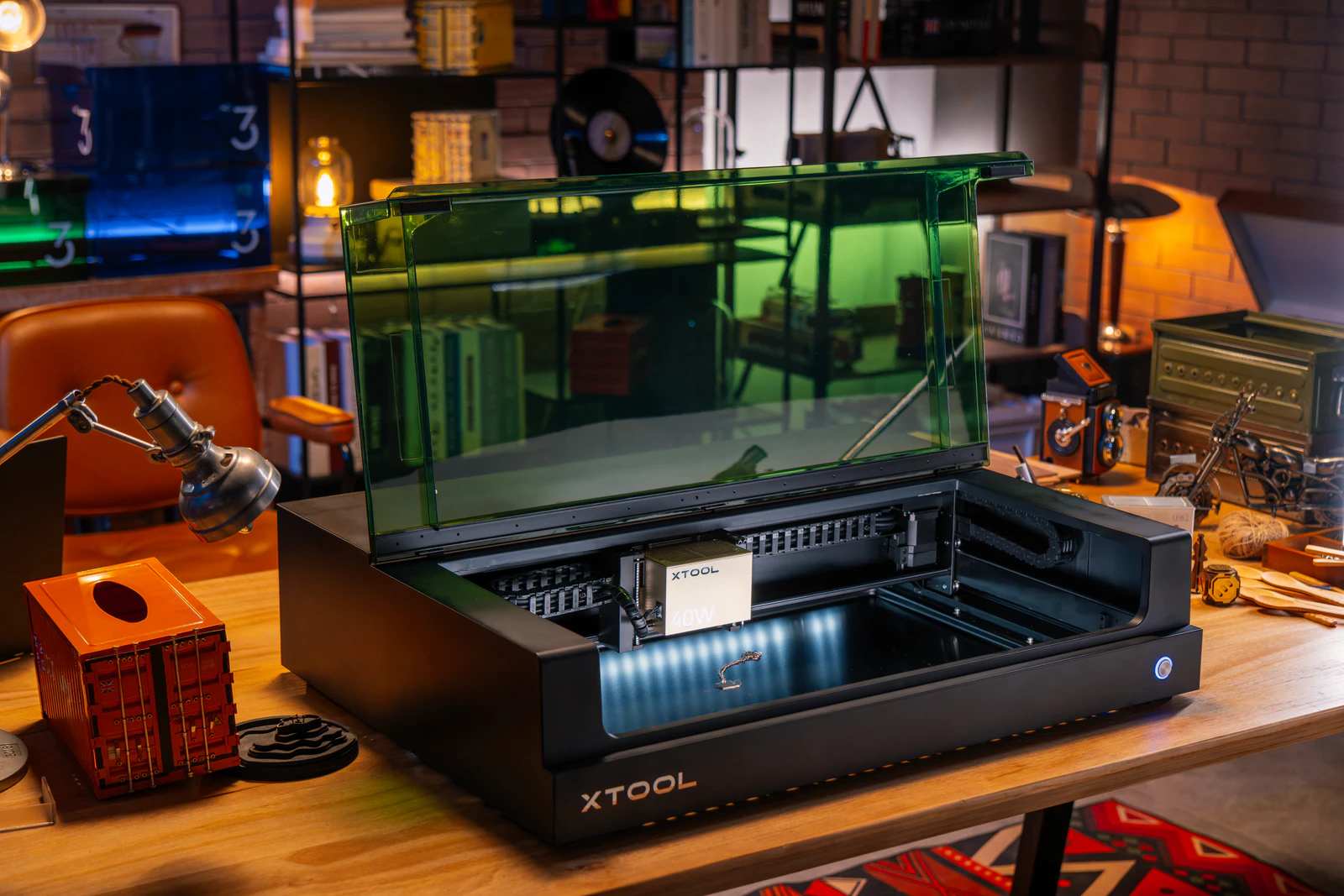xTool S1 with its lid open on a workshop table, with the 40 W laser module fitted.
